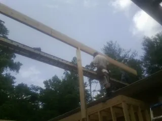Carpenter setting a ridge beam over a new addition frame — Ice Dam Removal by Roofing Brothers in Sheldahl