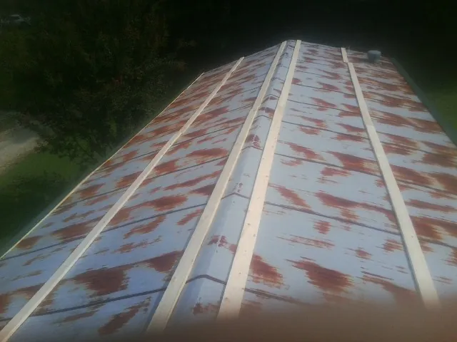 Rusted metal roof panels with new wood purlins before replacement — Storm Damage Roof Repair in Sheldahl by Roofing Brothers