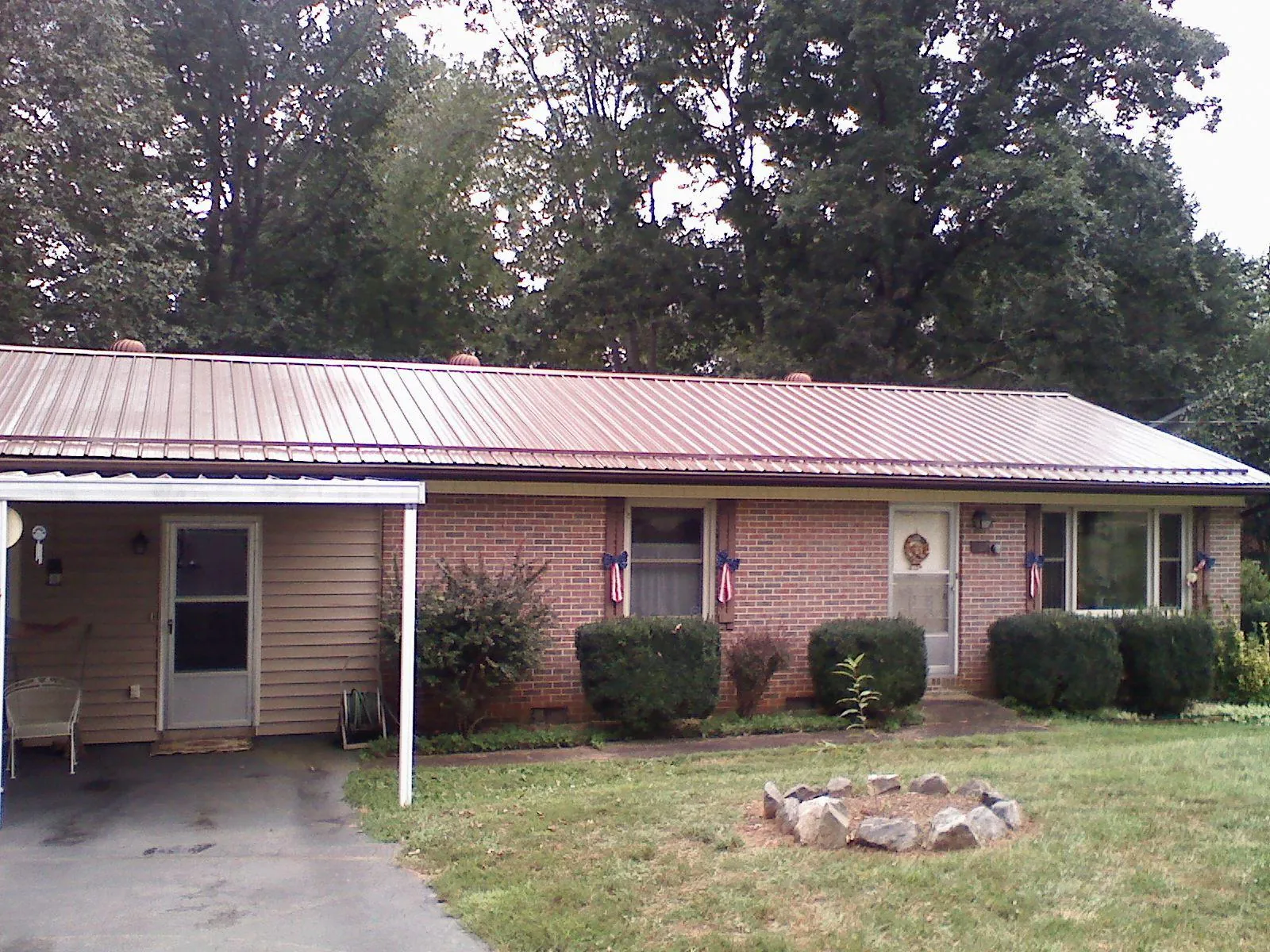 Bronze metal roof and carport on a brick ranch home — Roof Repair work by our crew in Sheldahl